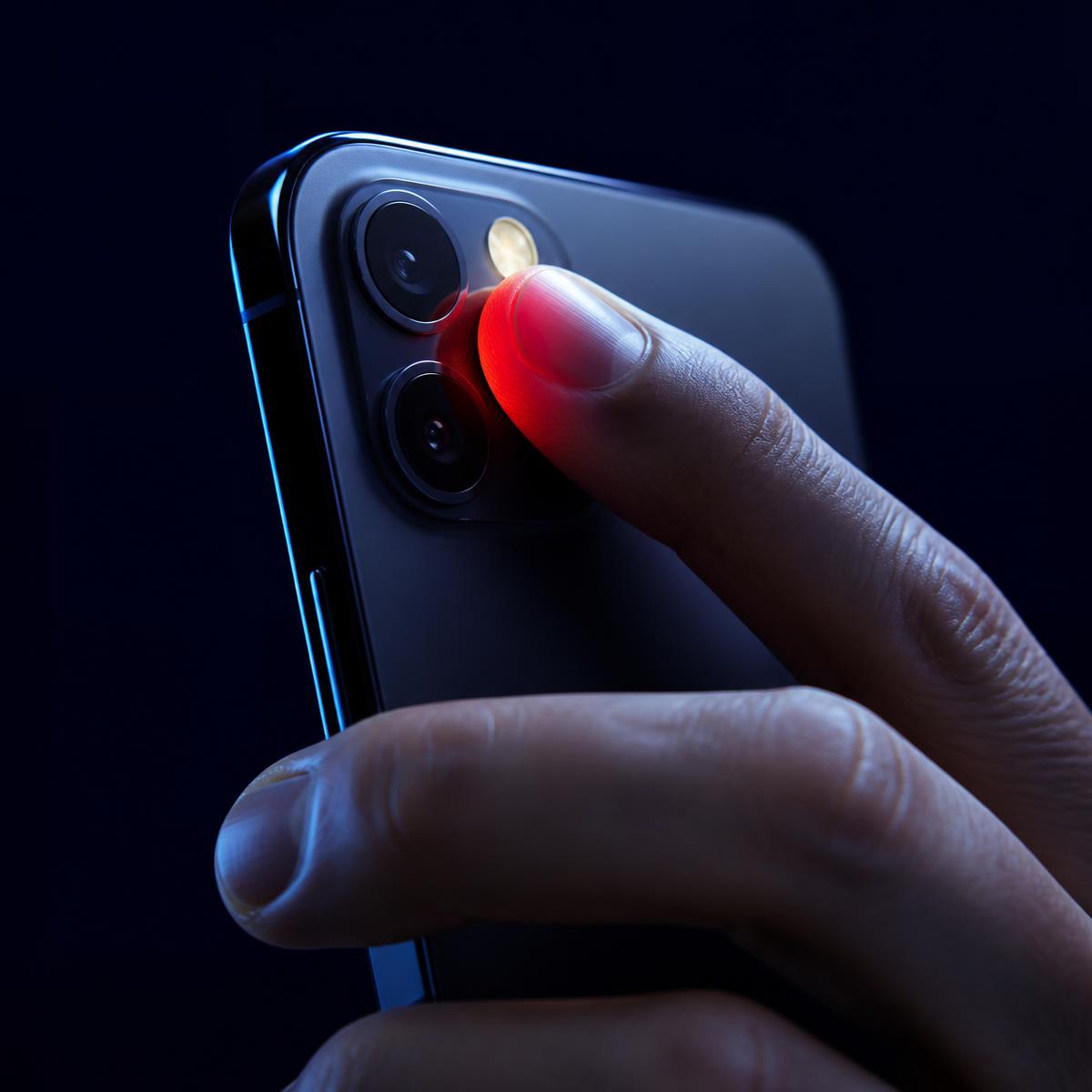 Dedo posicionado sobre a câmera e o flash do smartphone para leitura de fotopletismografia